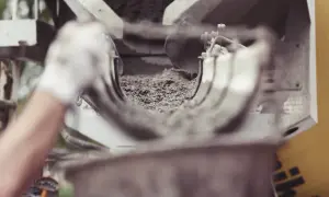 Betoniarka z świeżym betonem, ręka w rękawiczce.